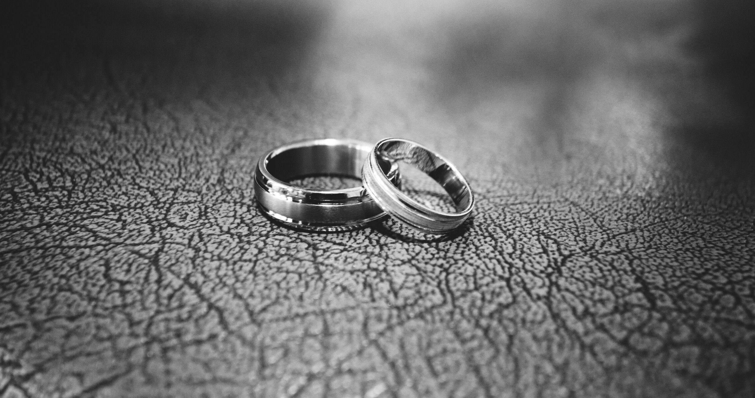 black and white photo of two wedding bands nestled on top of each other